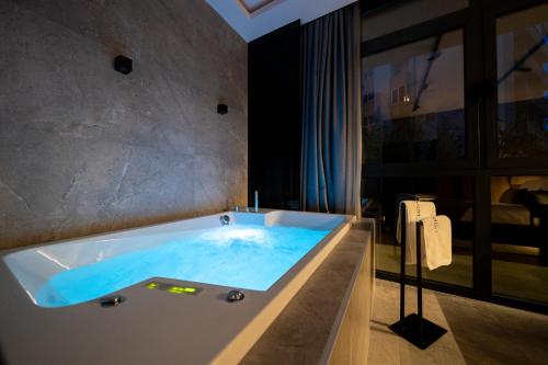 a bathroom with a tub with blue water in it at VELVET rooms & more in Zadar