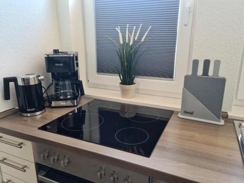 a kitchen counter with a coffee maker on a stove at Haus Hobbingshof Greetsiel in Greetsiel