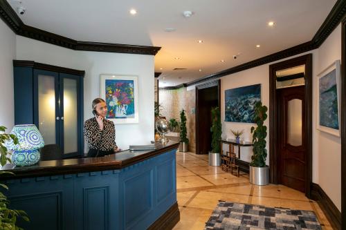 a woman standing at a bar in a lobby at Schull Harbour Hotel & Leisure Centre in Schull