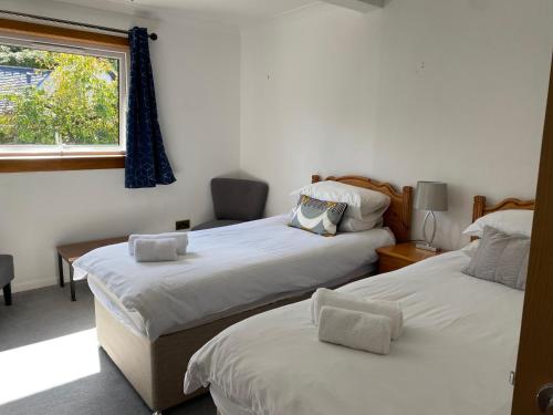een slaapkamer met 2 bedden en een raam bij Lyn leven cottages in Ballachulish