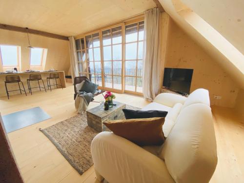Una sala de estar con un sofá blanco y una ventana grande. en Mitterattweng-Florian und Monika Clodi, en Traunkirchen