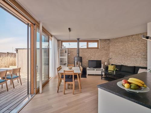 a kitchen and living room with a table and chairs at Exklusives Ferienhaus - Direkt am Neusiedler See in Neusiedl am See
