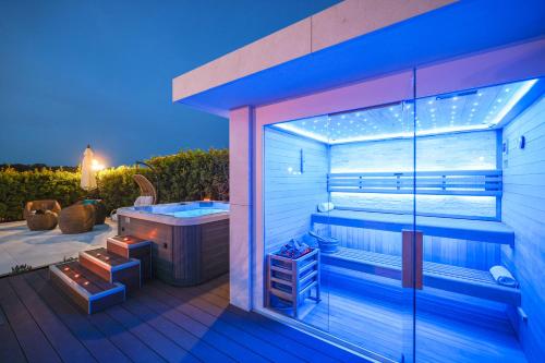 a bathroom with a tub on a deck at night at Villa Pino with Pool, Sauna & Jacuzzi in Petrcane