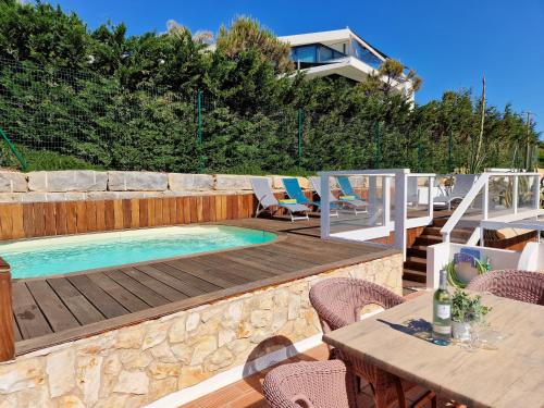 a swimming pool on a deck with a table and chairs at CASA VERDE - Beach House, Private Terrace & Pool in Benagil