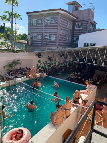 een groep mensen in het zwembad van een resort bij Nacho Hostel Cebu in Bulacao