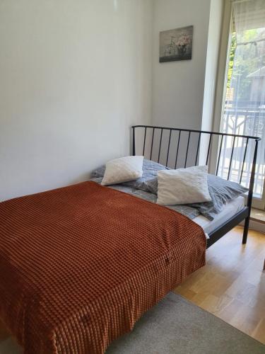 a bed with an orange comforter in a room at Apartament 3 - Bliżej Zdroju in Polanica-Zdrój