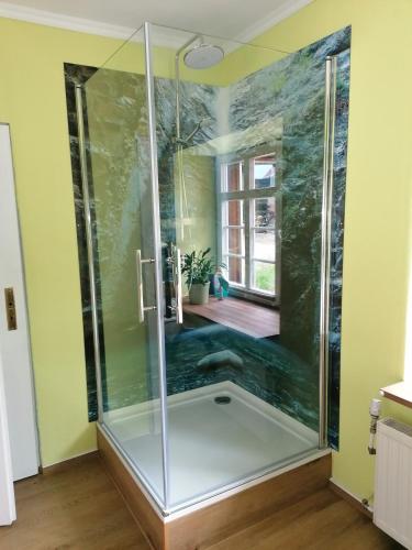 a shower with a glass door in a bathroom at Ferienwohnung Am Atelier in Rathenow