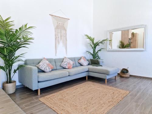 a living room with a blue couch and a mirror at CASA VERDE - Beach House, Private Terrace & Pool in Benagil