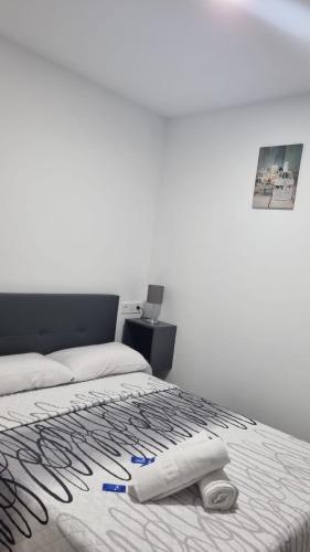 a bedroom with a bed with a black and white comforter at Hostal Vara Madrid in Madrid
