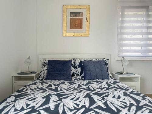 a bedroom with a bed with a blue and white comforter at Villa Luciana - Old town centre in Baška Voda