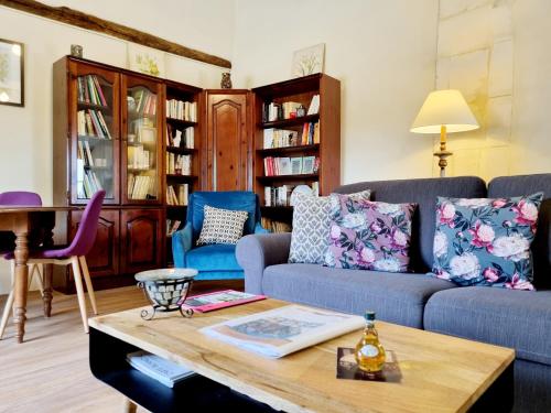 的住宿－Fleurs de vigne, gîte charentais au grand coeur，客厅配有沙发和桌子