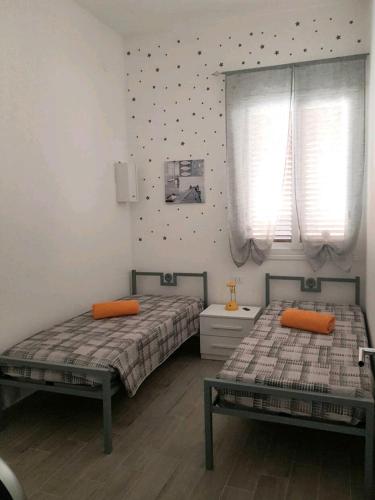 2 Betten in einem Schlafzimmer mit 2 Fenstern in der Unterkunft casa vacanze Rosanna in Balestrate