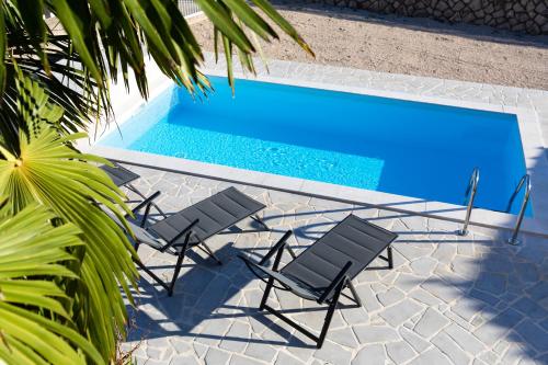 a couple of chairs and a swimming pool at Tom's House Njivice in Njivice