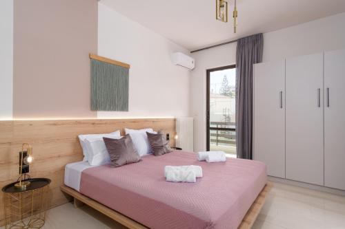 a bedroom with a large bed with two towels on it at NIMA1 4 bedroom apt centraly located in Rethimno in Rethymno