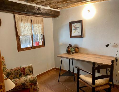 a room with a wooden table and a chair at Casa Artista in Pedro Bernardo