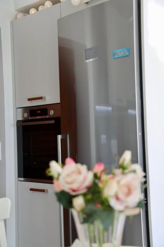 a vase of roses sitting on a table in a kitchen at Sunset View Stone House, Areopoli Mani in Areopolis