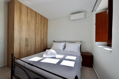 a bedroom with a bed with a wooden cabinet at Sunset View Stone House, Areopoli Mani in Areopolis