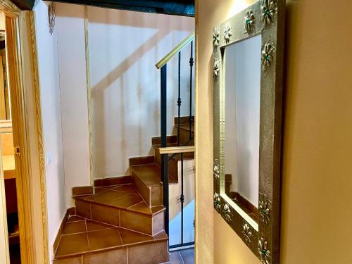 a mirror on a wall next to a staircase at Casa Artista in Pedro Bernardo