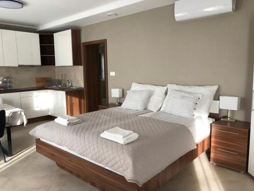 a bedroom with a large bed with two towels on it at Second Home Apartments Miskolctapolca in Miskolctapolca