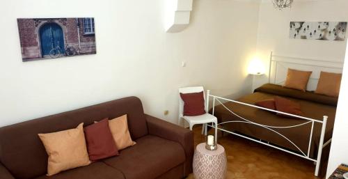ein Wohnzimmer mit einem Sofa und einem Bett in der Unterkunft HOUSE AURORA 50 in Ostuni