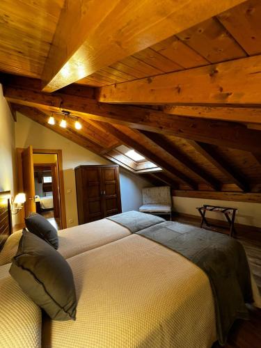 a bedroom with a large bed and wooden ceilings at Apartamentos Los Molinos in Llanes