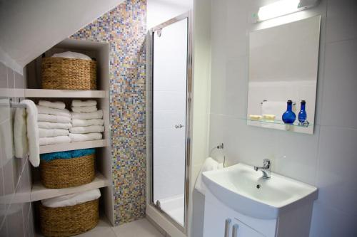 a bathroom with a sink and a mirror and towels at Cosy Apartment/ Explore The Area/Enjoy our Pub in Headford
