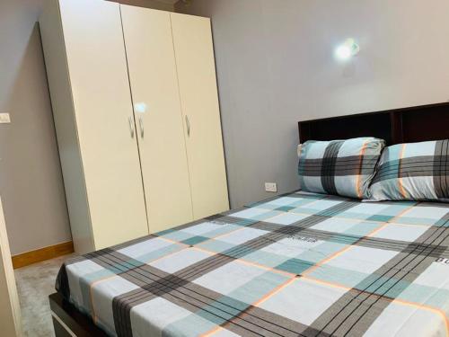 a bedroom with a bed and white cabinets at Mus homes in Accra