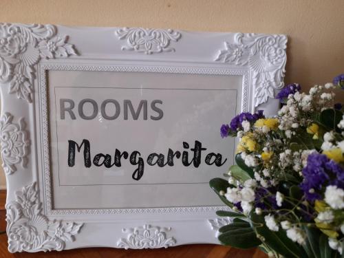 a white picture frame with a bouquet of flowers at Rooms Margarita in Zadar