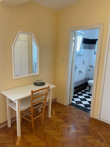 a dining room with a table and a mirror at Rooms Margarita in Zadar