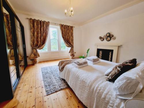 um quarto com uma cama grande e uma lareira em Luxury 5-bed Villa - Winfields House em Prestonpans