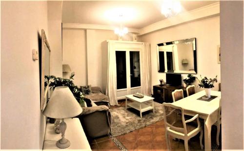een woonkamer met een bank en een tafel bij Elegant 2BR Apartment Puerto Banus Marbella just 12 Minutes Away by G00gIeMaps in Estepona