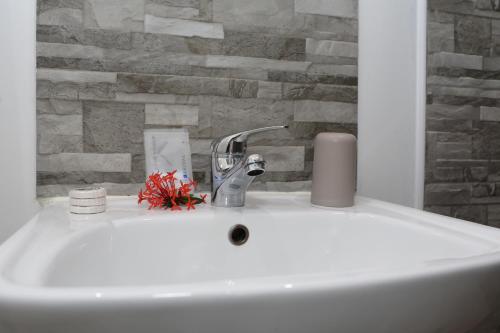 a bathroom sink with a faucet and a stone wall at Bungalow Harmony in Baie Mahault