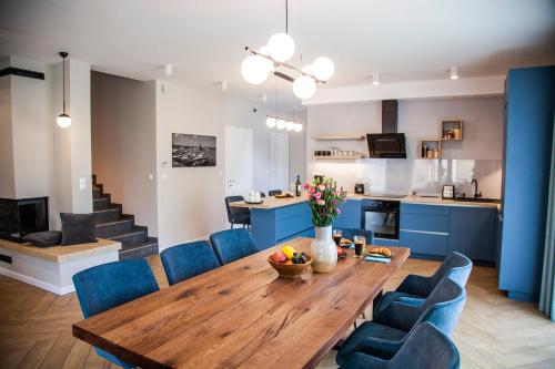 cocina y comedor con mesa de madera y sillas azules en BalaKing, en Zamárdi