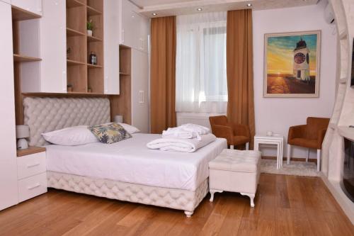 a bedroom with a white bed and a fireplace at Frajla in Novi Sad
