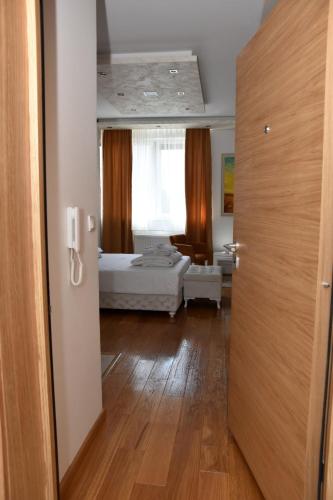 a room with a bedroom with a bed and a window at Frajla in Novi Sad