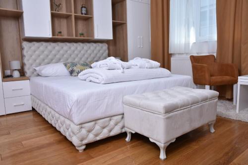 a bedroom with a white bed and a chair at Frajla in Novi Sad