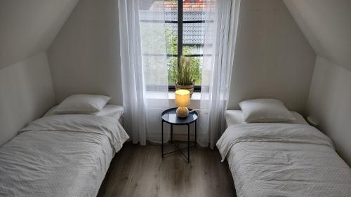 two beds in a small room with a window at Bambina's Guest House in Kristianstad