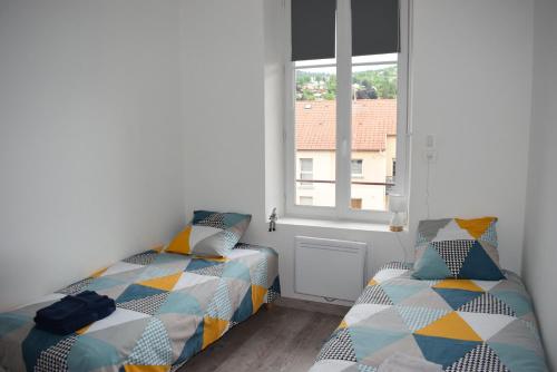 a bedroom with two beds and a window at Superbe T3 classé 3 étoiles Chez Cathy et Frank situé en plein centre de Gérardmer in Gérardmer