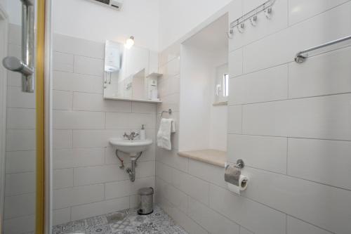 a white bathroom with a sink and a toilet at Town Place Apartment in Split