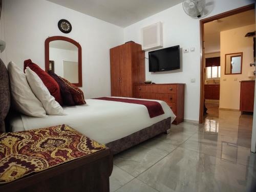 a hotel room with a bed and a television at Mali Country Hospitality in Eilat