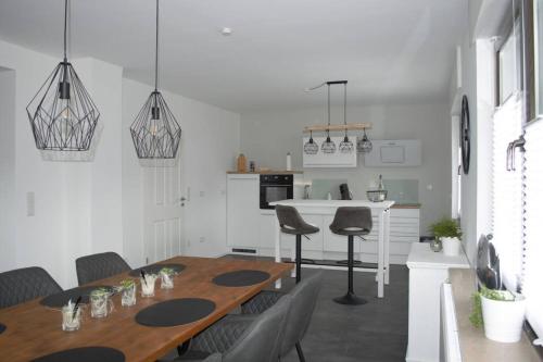 a kitchen and dining room with a wooden table and chairs at Ferienhaus Esten's Eifelheimat Wehr Eifel in Wehr