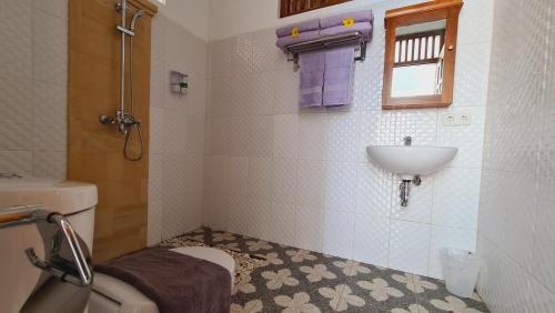 a bathroom with a sink and a toilet at HOME VILLA in Pabean Buleleng