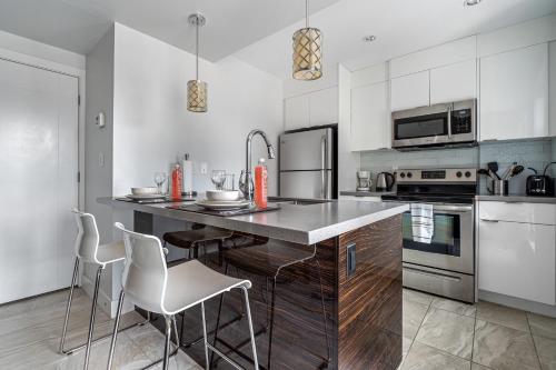 a kitchen with a counter with stools in it at ELEMENT ON FIRST by Manna in Calgary