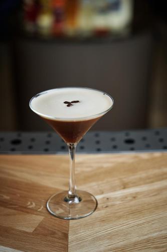 a martini glass sitting on top of a wooden table at The Market Hotel in Groningen