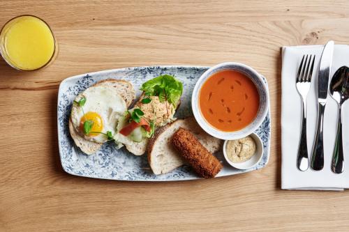 a plate with an egg sandwich and a cup of soup at The Market Hotel in Groningen