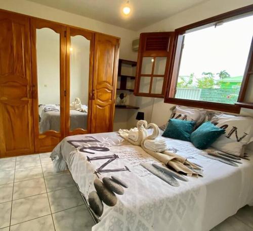 - une chambre avec un lit et des serviettes dans l'établissement Villa Kajoline à Petit-Bourg, à Petit-Bourg