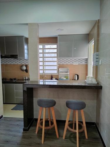 a kitchen with two stools at a kitchen counter at DARUL AMAN Homestay Jitra in Jitra