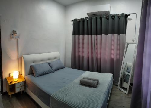 a small bedroom with a bed and a mirror at DARUL AMAN Homestay Jitra in Jitra