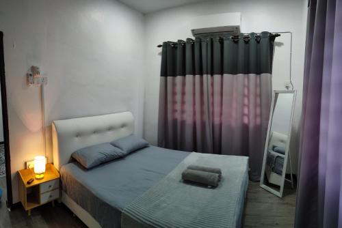 een kleine slaapkamer met een bed en een spiegel bij DARUL AMAN Homestay Jitra in Jitra