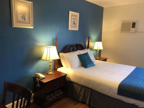 a bedroom with a bed with two lamps and a phone at Braeside Country Inn in Pictou